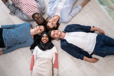 Zeminde yatan bir grup insanın üst görünüşü birlikteliği sembolize eder. Yüksek kalite fotoğraf