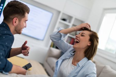 Oturma odasında bir koltukta otururken çift birlikte televizyon izler. Kız arkadaş ve erkek arkadaş kucaklaşır, sarılır, konuşur, gülümser ve TV Akımı Hizmetleri 'ni izler. Konforlu İç Modaya sahip Ev