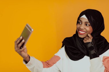 Sarı arka planda akıllı telefon kullanan Afro bir kadın. Yüksek kalite fotoğraf
