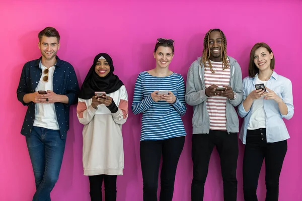 Diverse Teenager Benutzen Mobilgeräte Während Sie Vor Einem Bunten Hintergrund — Stockfoto
