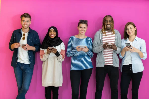 Diverse Teenager Benutzen Mobilgeräte Während Sie Vor Einem Bunten Hintergrund — Stockfoto