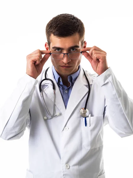 白いラボのコートに身を包んだ男性医師と白いカメラに孤立した笑顔で立っている聴診器を自信を持って 高品質の写真 — ストック写真