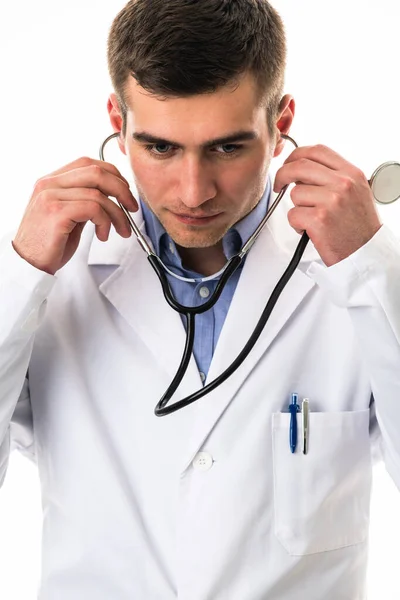白いコートにヒーローの肖像画 白い背景を背景にした医療病院に聴診器を持った朗らかな笑顔の若い医師 コロナウイルスCovid 19危険警報 高品質の写真 — ストック写真