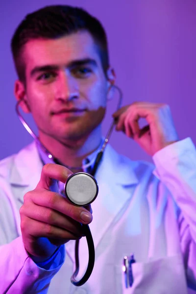 白のコートで英雄の肖像画 青とピンクの背景に立って医療病院で聴診器を持つ陽気な笑顔の若い医師 コロナウイルスCovid 19危険警報 高品質の写真 — ストック写真