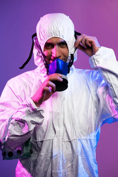 Coronavirus Covid 19大流行病 全球医疗流行病警报及蓝光和粉红霓虹灯背景下危险背景下身穿生物防护服和戴口罩的博士科学家 — 图库照片