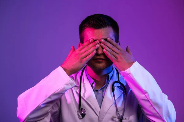 Coronavirus Covid 19危险警报 穿着白衣的英雄形象 年轻的医生面带微笑 带着听诊器站在医院里 面对着蓝色和粉色的背景 — 图库照片