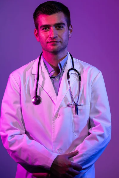 科罗纳维尤斯Covid 19危险警报白衣英雄的肖像 带着听诊器的快乐微笑的年轻医生站在蓝色和粉色的背景下 高质量的照片 — 图库照片
