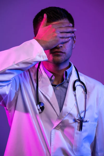 Coronavirus Covid 19危险警报 穿着白衣的英雄形象 年轻的医生面带微笑 带着听诊器站在医院里 面对着蓝色和粉色的背景 — 图库照片