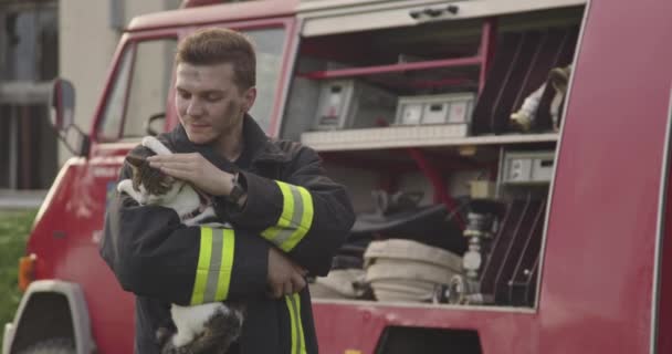 Närbild Porträtt Hjältemodig Brandman Skyddsdräkt Och Håller Räddade Katt Sina — Stockvideo