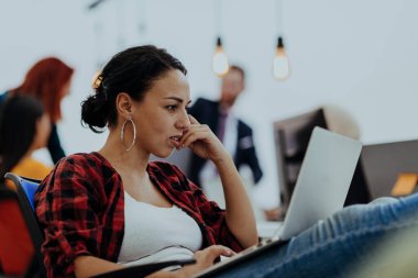 Modern ofiste laptopla çalışan mutlu bir kadın. Etrafında arkadaşları var.. 