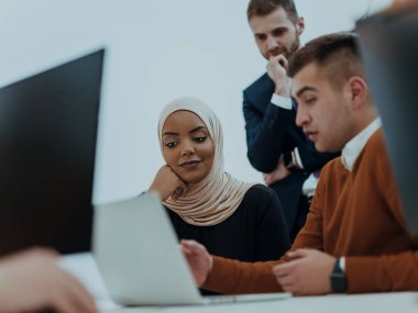 Masaüstü bilgisayarlar, dizüstü bilgisayarlar üzerinde çalışan ve fikirlerini modern bir ofis alanında paylaşan çok ırklı çalışma arkadaşları. Genç nüfuzlu kişiler çevrimiçi pazarlama projeleri üzerinde çalışıyorlar