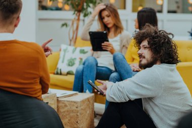 Masaüstü bilgisayarlar, dizüstü bilgisayarlar üzerinde çalışan ve fikirlerini modern bir ofis alanında paylaşan çok ırklı çalışma arkadaşları. Genç nüfuzlu kişiler çevrimiçi pazarlama projeleri üzerinde çalışıyorlar