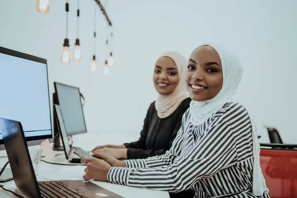 beautiful modern African American Muslim businesswoman in office, wearing hijab at creative modern startup coworking space. High quality photo