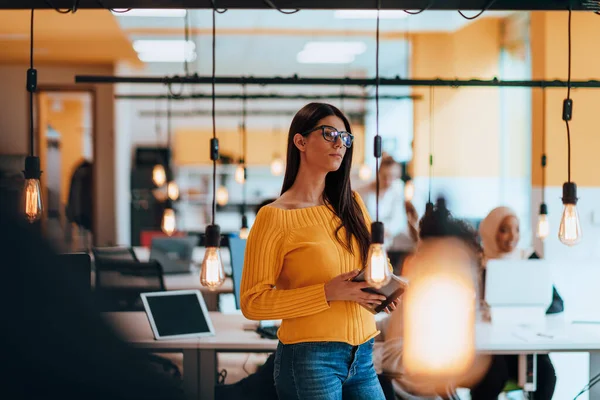 stock image Female boss, manager executive posing in a modern startup office while being surrounded by her coworkers, team