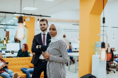 Modern bir ofiste ekibiyle poz veren resmi bir iş adamı ve Afrikalı genç bir iş kadınının portresi. Pazarlama konsepti. Çok ırklı toplum