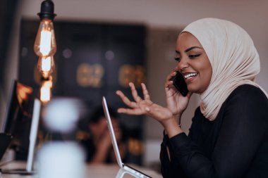 Genç Afrikalı Amerikalı iş kadını modern bir ofiste akıllı bir telefonla konuşuyor. Pazarlama konsepti. Çok ırklı toplum. 