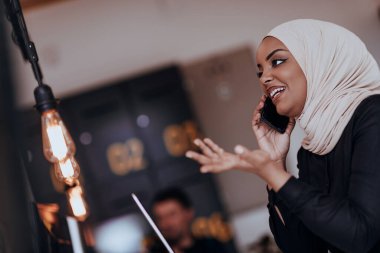 Genç Afrikalı Amerikalı iş kadını modern bir ofiste akıllı bir telefonla konuşuyor. Pazarlama konsepti. Çok ırklı toplum. 