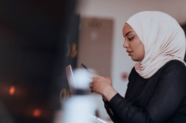 Genç Afrikalı Amerikalı iş kadını modern bir ofiste akıllı bir telefonla konuşuyor. Pazarlama konsepti. Çok ırklı toplum. 