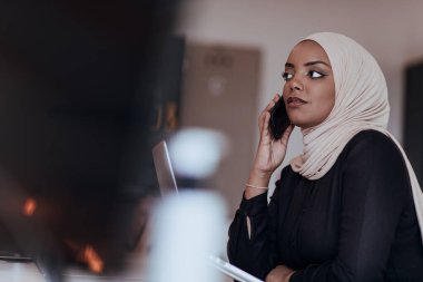 Genç Afrikalı Amerikalı iş kadını modern bir ofiste akıllı bir telefonla konuşuyor. Pazarlama konsepti. Çok ırklı toplum. 