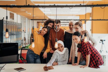 İş adamları ekibi modern açık uzay ofisinde akıllı telefondan fotoğraf çekiyor..