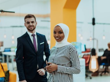 Modern bir ofiste ekibiyle poz veren resmi bir iş adamı ve Afrikalı genç bir iş kadınının portresi. Pazarlama konsepti. Çok ırklı toplum