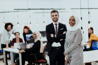 Modern bir ofiste ekibiyle poz veren resmi bir iş adamı ve Afrikalı genç bir iş kadınının portresi. Pazarlama konsepti. Çok ırklı toplum