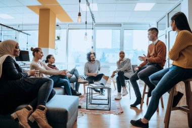 Genç tasarımcı, konferans odasındaki ortaklarına proje hakkında yeni fikirler veriyor. İşadamları yeni iş projelerini tartışıyorlar.