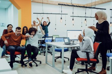 Takım oluşturma ve ofis eğlencesi. Şık giyinen neşeli iş adamları ofis sandalyelerinde yarışırken eğleniyorlar ve gülümsüyorlar.