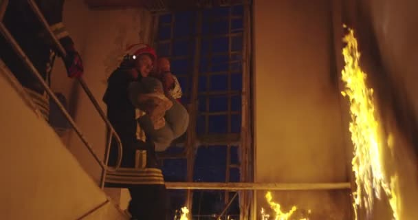 Dappere Brandweerman Daalt Van Een Brandend Gebouw Houdt Het Meisje — Stockvideo