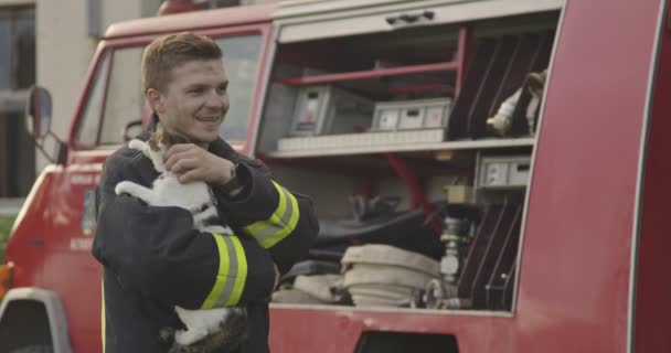 Närbild Porträtt Hjältemodig Brandman Skyddsdräkt Och Håller Räddade Katt Sina — Stockvideo