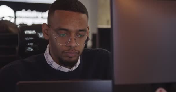 Молодой Афроамериканский Бизнесмен Программист Очках Сидящий Современном Коворкинге Работающий Компьютером — стоковое видео