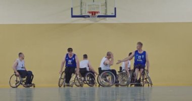 Tekerlekli Sandalye Basketbol Oyunu: Oyuncular Yarışıyor, Top Sürüyor, Pas Veriyor, Atış Yapıyor ve Gol Atıyor. Özürlü İnsanların Kutlanması. Sinematik Ağır Çekim. Kapsama konsepti. Yüksek kalite 4K
