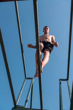 Genç adam temiz nehre atlamaya hazırlanıyor, yüzüyor, yaz tatillerinde vakit geçiriyor. Yüksek kalite fotoğraf