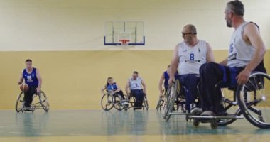 Tekerlekli Sandalye Basketbol Oyunu: Oyuncular Yarışıyor, Top Sürüyor, Pas Veriyor, Atış Yapıyor ve Gol Atıyor. Özürlü İnsanların Kutlanması. Sinematik Ağır Çekim. Kapsama konsepti. Yüksek kalite 4K