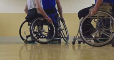 Tekerlekli sandalyede oturan ve spor salonunda basketbol oynayan engelli bir sporcunun yakın çekimi. Seçici odaklanma. Yüksek kalite 4K video. 