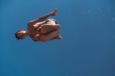 Genç adam temiz nehre atlamaya hazırlanıyor, yüzüyor, yaz tatillerinde vakit geçiriyor. Yüksek kalite fotoğraf