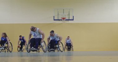 Tekerlekli Sandalye Basketbol Oyunu: Oyuncular Yarışıyor, Top Sürüyor, Pas Veriyor, Atış Yapıyor ve Gol Atıyor. Özürlü İnsanların Kutlanması. Sinematik Ağır Çekim. Kapsama konsepti. Yüksek kalite 4K