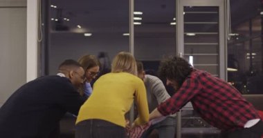 Coşkulu, çoklu etnik çeşitliliğe sahip genç iş adamları iş dünyasındaki ortak başarılarını ya da zaferlerini kutlarken eğleniyor. Gülümseyen çok ırklı çalışanlar iyi sonuçlar aldıkları için heyecanlılar. Takım çalışması.