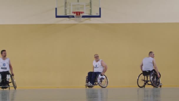 車いすバスケットボールゲーム 選手の競争 ドリブルボール シュートとゴールのスコア 障害者の祝典 映画のスローモーション 包含概念 高品質4K — ストック動画