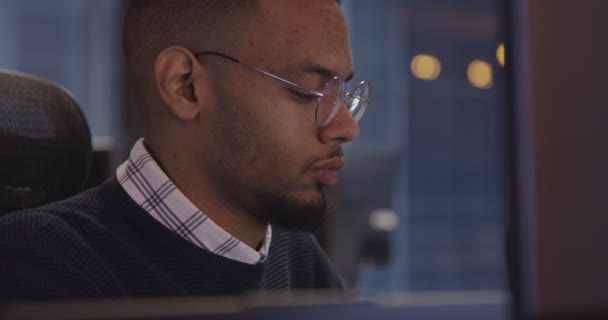 Молодой Афроамериканский Бизнесмен Программист Очках Сидящий Современном Коворкинге Работающий Компьютером — стоковое видео