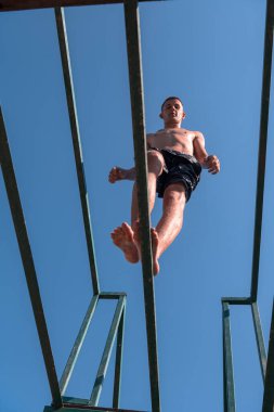 Genç adam temiz nehre atlamaya hazırlanıyor, yüzüyor, yaz tatillerinde vakit geçiriyor. Yüksek kalite fotoğraf