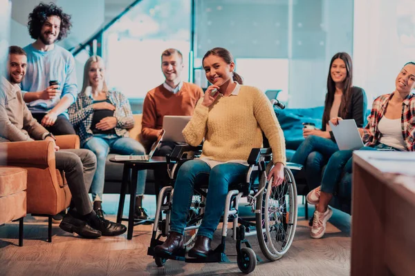 一个坐在轮椅上的女商人和团队在一个现代化的办公室举行商务会议 一群年轻的自由职业者就新的在线商务项目达成了一致 — 图库照片