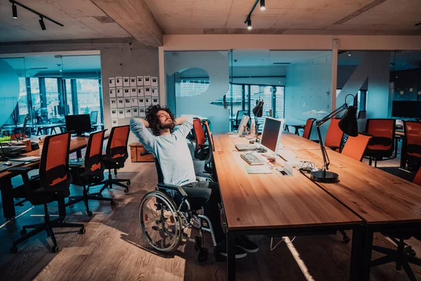 一个坐在轮椅上的残疾人商人深夜一个人在办公室的办公桌旁加班 高质量的照片 — 图库照片