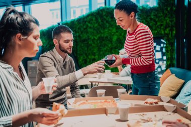 Ofiste farklı iş arkadaşlarıyla pizza yemek, mutlu çoklu etnik çalışanlar öğle yemeğinde birlikte eğlenmek, güzel sohbetler ve duygular..