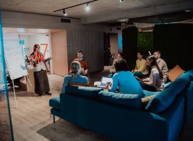 Yaşlı bir Müslüman iş kadını, modern bir ofisteki genç ve çeşitli bir ekibe bir proje sunuyor. Yüksek kalite fotoğraf