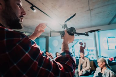 Modern bir ofiste sakallı bir adam genç ve çeşitli takımına bir dronun nasıl çalıştığını anlatıyor. Yüksek kalite fotoğraf
