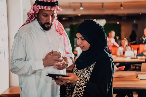 現代のガラスオフィスでタブレットやスマートフォンを使用しながらビジネスプロジェクトを議論イスラム教徒のヒジャーブ女性とアラブの指導者実業家の肖像写真 — ストック写真