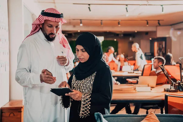 現代のガラスオフィスでタブレットやスマートフォンを使用しながらビジネスプロジェクトを議論イスラム教徒のヒジャーブ女性とアラブの指導者実業家の肖像写真 — ストック写真