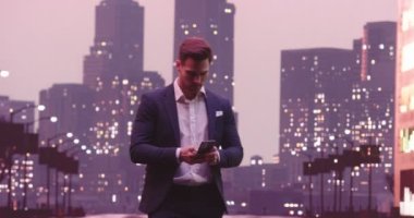 New York caddesinde akıllı telefon kullanan yakışıklı bir iş adamı, Wall Street bölgesi. Başarılı bir iş adamının günlük hayatı. Yüksek kalite 8K görüntü
