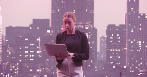 金融分析师或律师使用笔记本电脑 站在街道上与美丽的夜晚纽约市的天际线与摩天大楼 有自信的女商人随便穿正装 高质量的8K镜头 — 图库视频影像